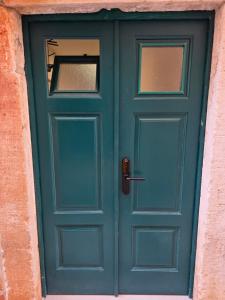 a green door in a building with a window at Lausa Dubrovnik Rooms in Dubrovnik