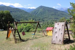 an old playground equipment in a field with mountains at Villa Gina in Villar Pellice