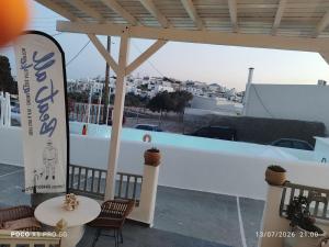 a sign on a building with a table and chairs at Hotel Apartments Giannis in Adamantas