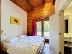 a bedroom with a bed in a room with a window at Le Refuge du Trappeur in Hour