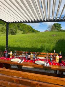 a picnic table with food and drinks and a field at Joy Chalet in Plaiu +32 photos