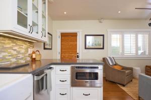 a kitchen with a stove top oven next to a couch at Playa One Bedroom (251) in Carpinteria