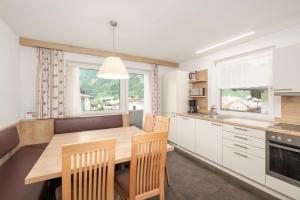 a kitchen with a wooden table and two chairs at Haus St. Christoph in Mayrhofen +10 photos