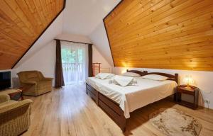 a bedroom with a bed and a wooden ceiling at La Moară la Făgădău in Tuşnad