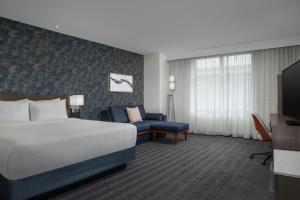 a hotel room with a bed and a couch at Courtyard by Marriott Richmond Downtown in Richmond
