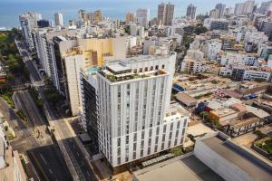 an aerial view of a tall white building in a city at Humano, Lima, a Tribute Portfolio Hotel in Lima