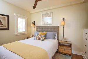 a bedroom with a large bed with blue and yellow pillows at Playa One Bedroom (253) in Carpinteria