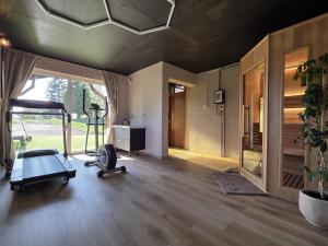 a gym with a treadmill and a chair in a room at Kopitnik cosy cabin in Dol pri Hrastniku