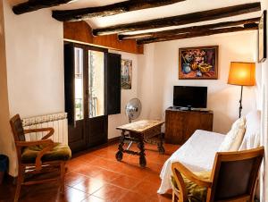 a bedroom with a bed and a desk and a television at Casa amb terrassa i vistes a la vall - Cal Taverner in Montsonis