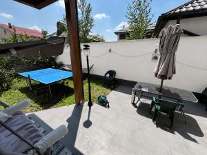 a patio with a table and an umbrella at Casa Capibarei 3 in Bragadiru