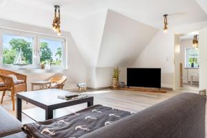 a living room with a couch and a tv at Ankerhaus 2 in Trent