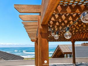 a view of the ocean from the patio of a beach house at Residencial La Ferrugem - Garopaba/SC in Garopaba +61 photos