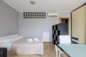 a bedroom with a bed and a table and a refrigerator at Turin Airport apt G in Leinì +25 photos