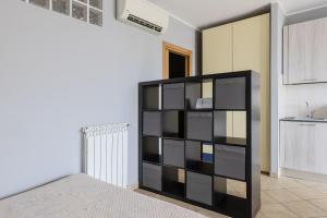 a black book shelf in a room with a kitchen at Turin Airport apt G in Leinì