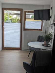 a living room with a table and two windows at Ferienwohnung in Ranzig - klein aber fein in Tauche