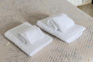 three white towels sitting on top of a bed at Turin Airport apt G in Leinì