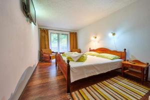 a bedroom with a large bed and a window at La Moară la Făgădău in Tuşnad +8 photos