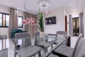 a dining room with a glass table and chairs at Logements Majeo in Kribi