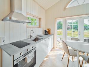 a kitchen with a sink and a table with chairs at Lakeside Herrestad in Värnamo