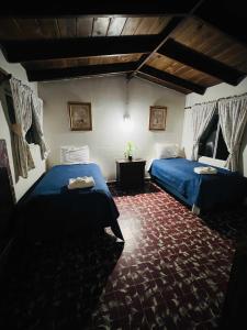 a bedroom with two beds and a red carpet at Rancho Meling in Camalú