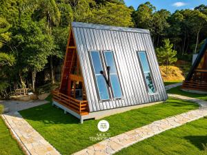 a tiny house on the grass in a yard at Chalés da Lagoa - Imaruí/SC in Imaruí