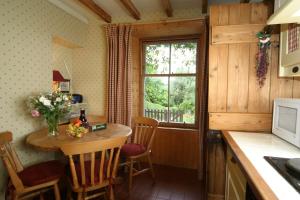 eine Küche mit einem kleinen Tisch und einem Fenster in der Unterkunft Springburn Cottage in Strachur