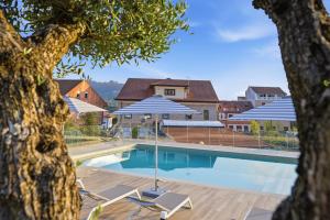 a swimming pool with two chairs and an umbrella at Pardavila 57 Slow Hotel in Marín