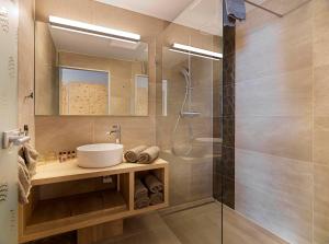 a bathroom with a sink and a shower at Hotel Zirbenhof in Hochfugen
