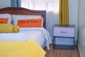 a bedroom with a bed and a night stand next to a bed at Micasa Homes BNB D2 in Limuru
