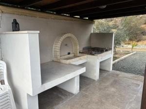 an outdoor kitchen with a bench and a grill at Sofros To Apomero in Ayios Pavlos