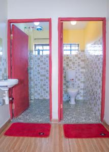 a bathroom with a red door and a toilet at Micasa Homes BNB D2 in Limuru