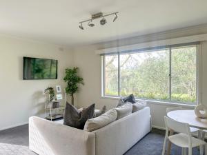 a living room with a couch and a table at Cozy & Spacious Family Unit Mt Martha in Mount Martha