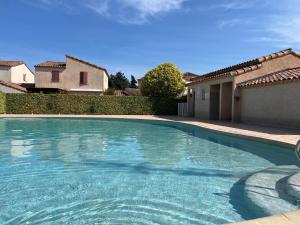 a large swimming pool in a yard with a house at La Paloma in Aigues-Mortes