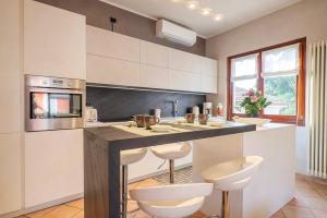 a kitchen with a island with two stools and a counter at Casa Vacanza da Nicolo by Lago Reisen in Pallanza