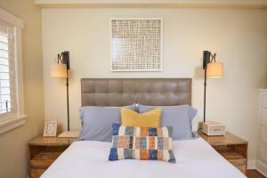 a bedroom with a bed with blue and yellow pillows at Playa One Bedroom (253) in Carpinteria +4 photos