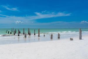 a beach with wooden posts in the water at Lovers Key #508 by Sun Palace Vacations in Fort Myers Beach
