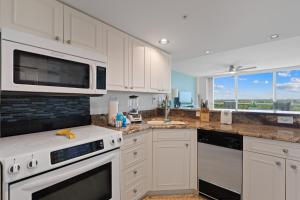 a kitchen with white cabinets and a microwave at Lovers Key #508 by Sun Palace Vacations in Fort Myers Beach