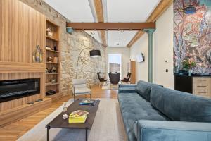 a living room with a blue couch and a stone wall at Pardavila 57 Slow Hotel in Marín