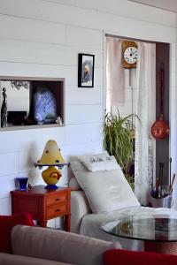a living room with a couch and a table and a clock at Chambre d'hotes la Mainguy in Ruca