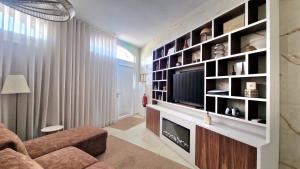 a living room with a large entertainment center with a television at Cidadela do Viriato in Viseu