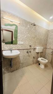 a bathroom with a toilet and a sink at Hotel Malabar Plaza in Cochin