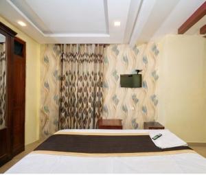 a bedroom with a bed and a tv on the wall at Hotel Malabar Plaza in Cochin