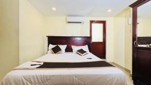 a bedroom with a large bed with a wooden headboard at Hotel Malabar Plaza in Cochin +6 photos