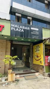 a restaurant with a sign on the front of a building at Hotel Malabar Plaza in Cochin
