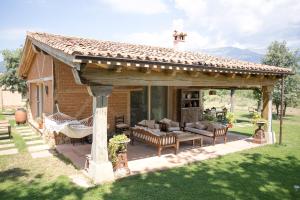 a pavilion with a couch and chairs in a yard at Finca El Ropero Eco-friendly house in Villanueva de la Vera