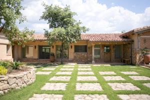 a house with a stone pathway in the yard at Finca El Ropero Eco-friendly house in Villanueva de la Vera +8 photos