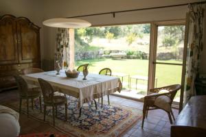 a dining room with a table and chairs and a large window at Finca El Ropero Eco-friendly house in Villanueva de la Vera