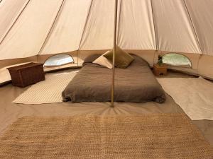 a bed in a tent in a room at Meadows - Eco Retreat in Bitton