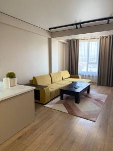 a living room with a couch and a coffee table at Lux Residence 2 in Osh