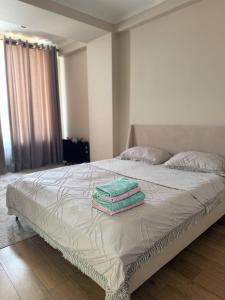 a bedroom with a bed with two towels on it at Lux Residence 2 in Osh